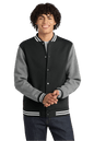 Black Sport-Tek varsity jacket with vintage heather fabric, featuring classic striped cuffs and collar, customizable or plain design.