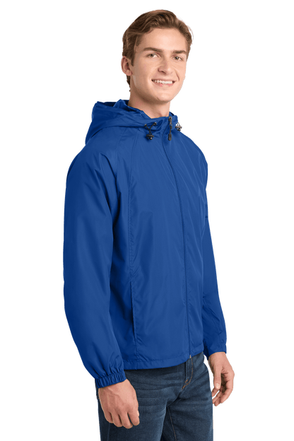 Sport-Tek hooded raglan windbreaker jacket in true royal color, shown from the side view. Lightweight and sporty design.