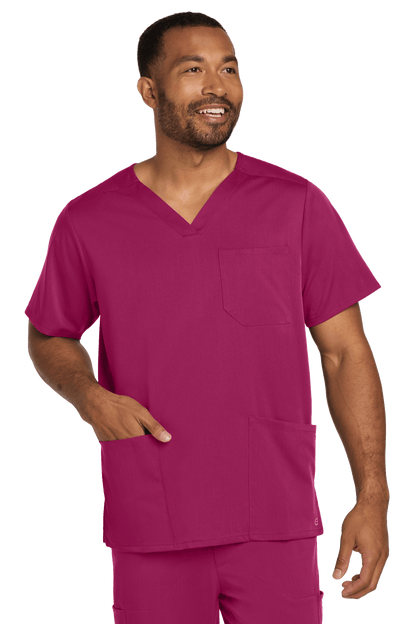 Male nurse wearing Wink Men's Premiere Flex V-Neck Scrub Top in wine color, front view showing the printed design.