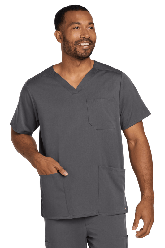 Male nurse wearing Wink Men's Premiere Flex V-Neck Scrub Top in pewter grey, front view showing print design and comfortable fit.