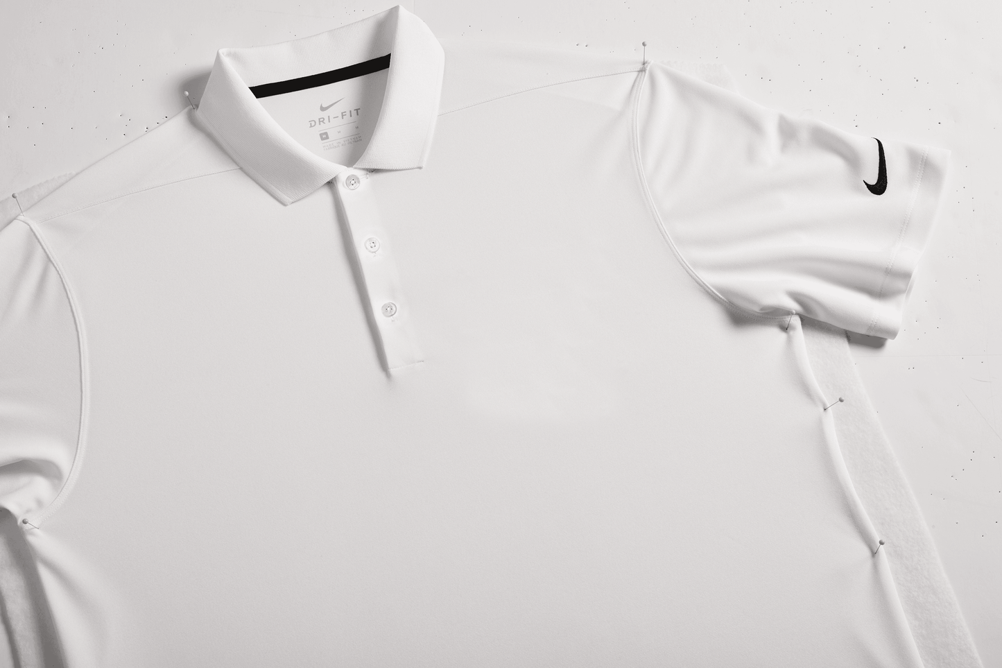 Nike men's Dri-FIT polo shirt with white print design, shown in a close-up view, suitable for customization or plain wear.