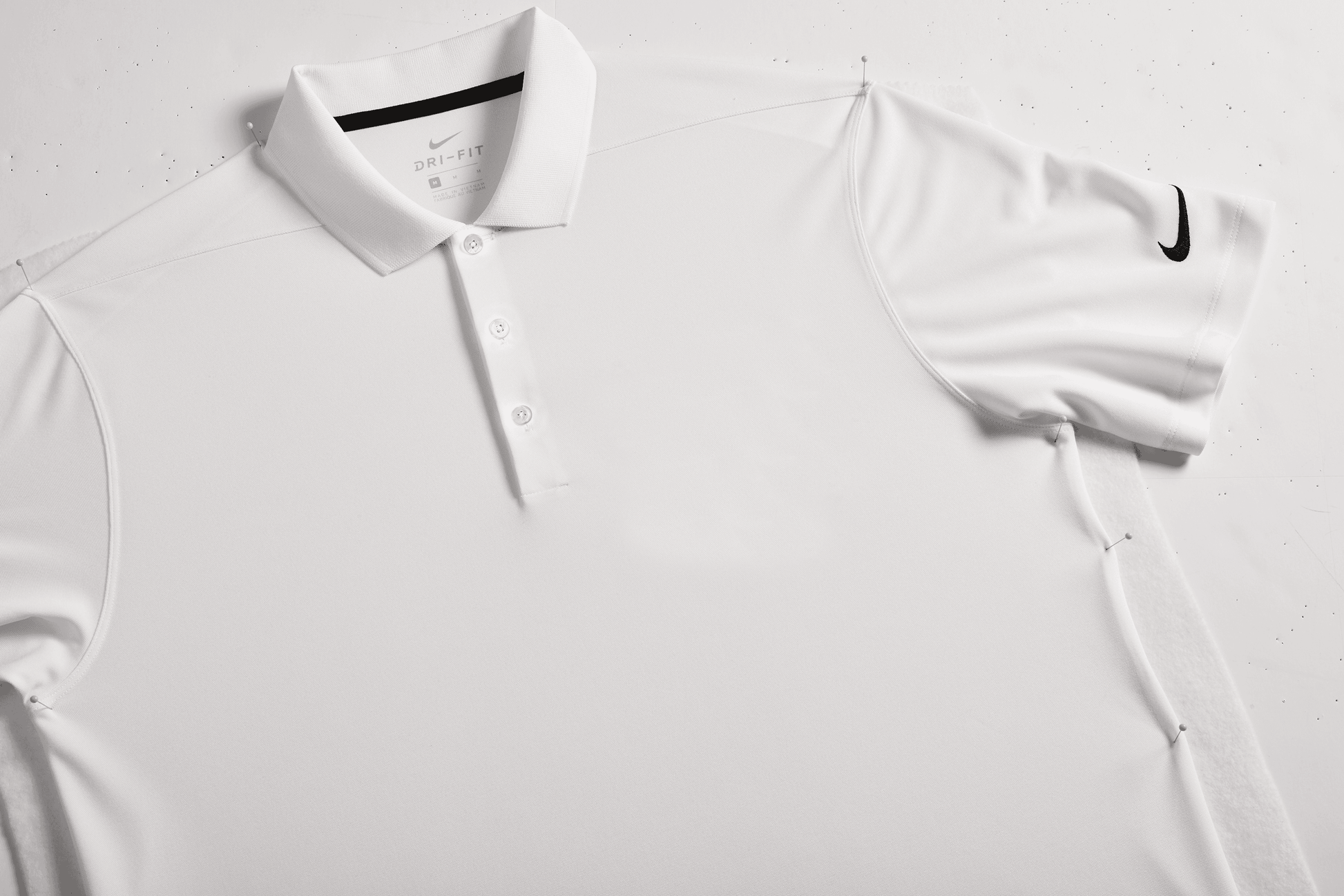 Nike men's Dri-FIT polo shirt with white print design, shown in a close-up view, suitable for customization or plain wear.