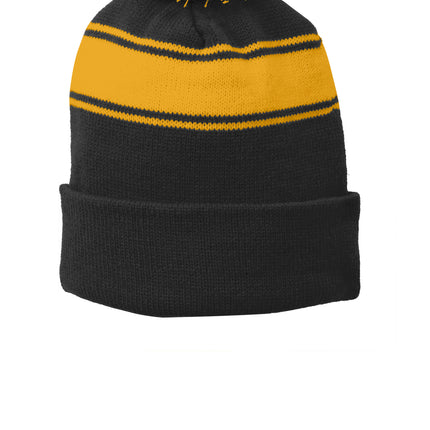 Black and gold Sport-Tek® stripe pom pom beanie with a front view, showcasing cozy knit fabric and stylish design.