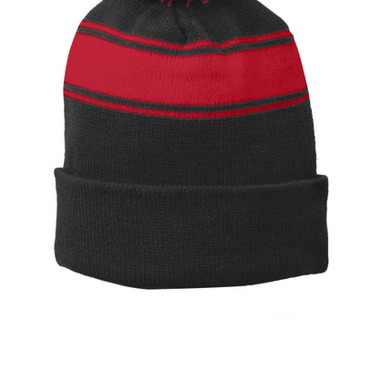 Black and true red Sport-Tek® stripe pom pom beanie with a flat front, featuring bold color blocks and a cozy knit design.