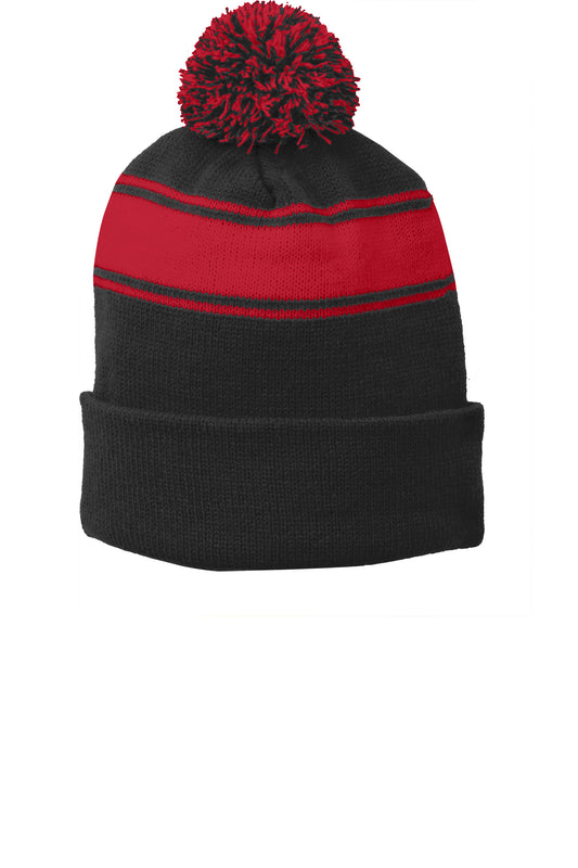 Black and true red Sport-Tek® stripe pom pom beanie with a flat front, featuring bold color blocks and a cozy knit design.