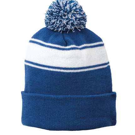Royal and white Sport-Tek® Stripe Pom Pom Beanie with a fluffy pom-pom on top, perfect for cold weather.