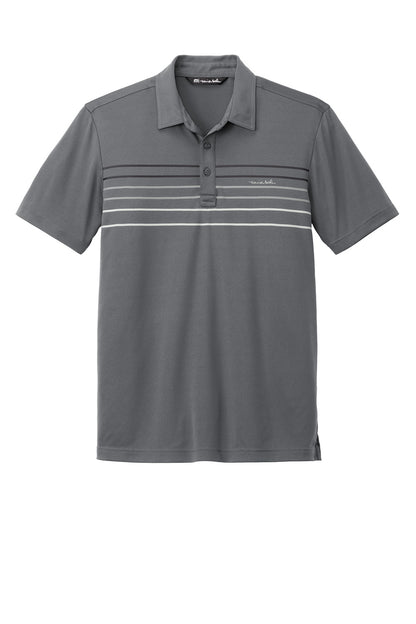 Dark grey TravisMathew Coto Chest Stripe Polo shirt with a flat front and striped design, displayed on a plain background.