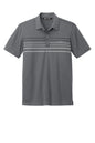 Dark grey TravisMathew Coto Chest Stripe Polo shirt with a flat front and striped design, displayed on a plain background.