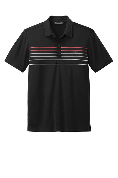 Black TravisMathew Coto Chest Stripe Polo shirt with front chest stripe detail, laid flat for display.