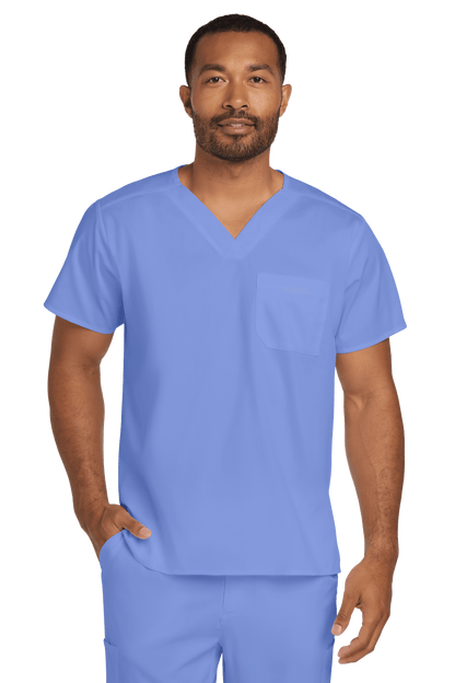 Light blue unisex medical scrubs top by Wink with a V-neck and flexible chest pocket, designed for comfortable workwear.