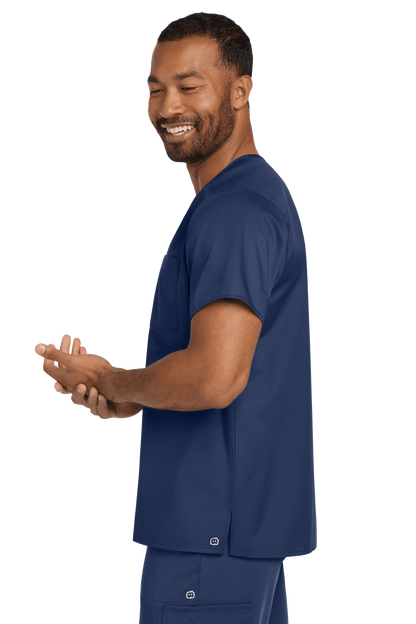 Navy unisex medical scrubs V-neck top with flex chest pocket, worn by a model side view, by Wink.