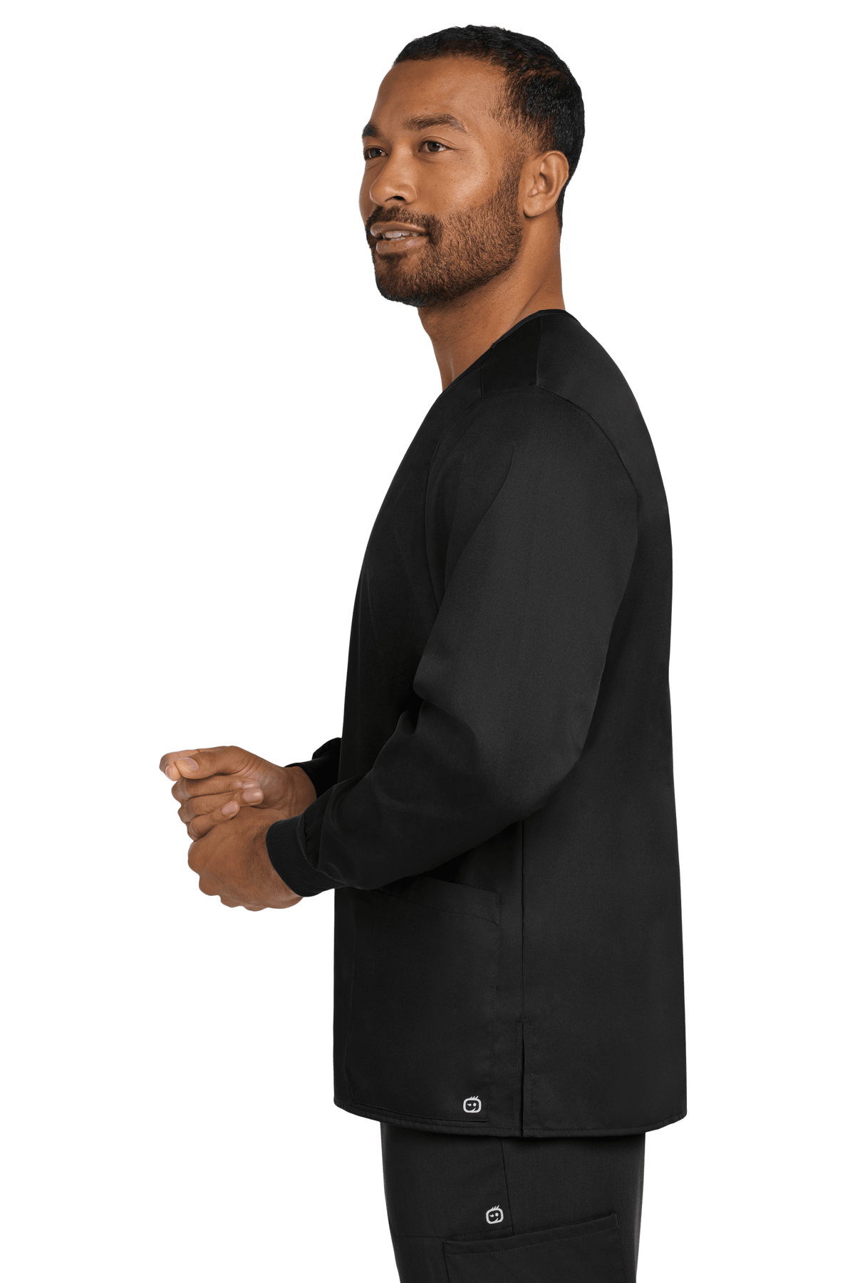 Unisex Wink workwear flex snap-front scrub jacket in black, shown from the side with a professional fit and functional design.