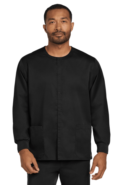 Unisex black Wink workwear scrub jacket with a snap-front design, shown from the front view on a model.