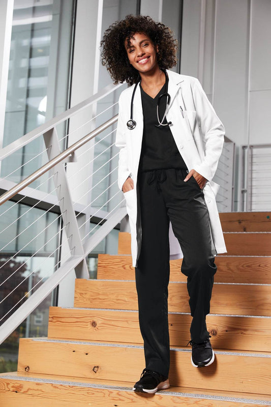 Women’s long lab coat by Wink, white scrub coat with front pockets, suitable for medical professionals or lab staff.