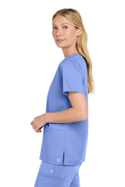 Light blue Women's Medical WorkFlex™ Mock Wrap Top by Wink, featuring a stylish scrub print, shown from the side view.