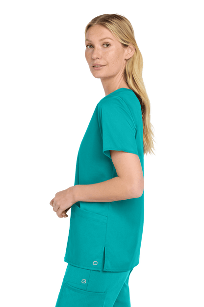 Wink Women's Medical WorkFlex™ mock wrap scrub top with teal print, shown from side view on a model.