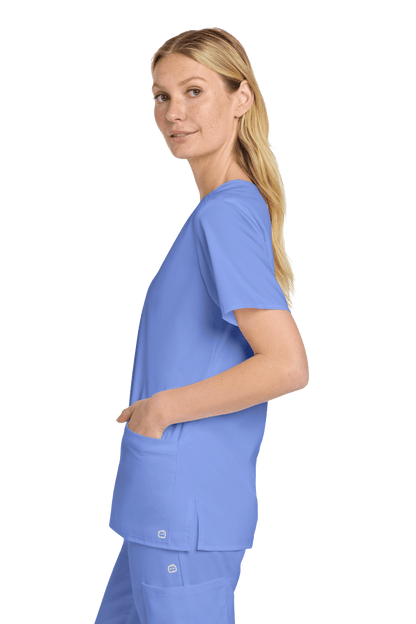 Light blue women's Wink medical scrub top with V-neck and print design, shown from a side view.