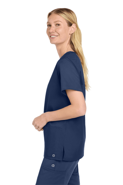 Women’s navy blue Wink medical scrub top with a flexible V-neck and printed design, shown from a side view.