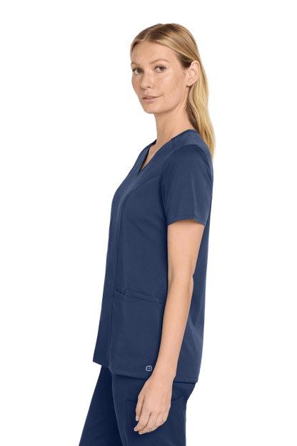 Women’s navy blue V-neck scrub top from Wink's Premiere Flex collection, shown from the side with a comfortable fit.